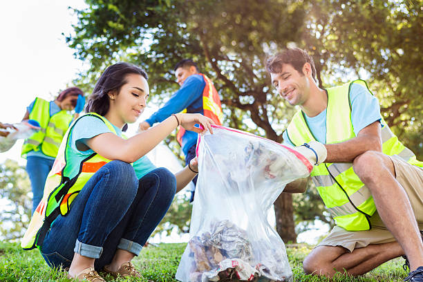 Happy community service people cleaning up the park