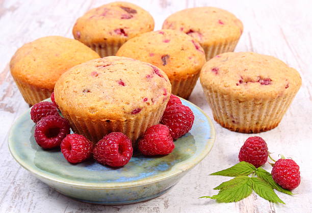 istock Fresh baked muffins with raspberries on old wooden background 578282012