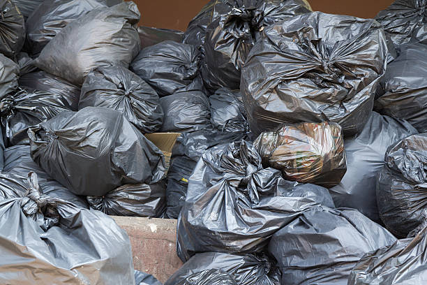 istock Black trash bags pile in recycle center 578282414