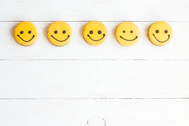 Smiley faces on wooden white background. Top view, flat lay