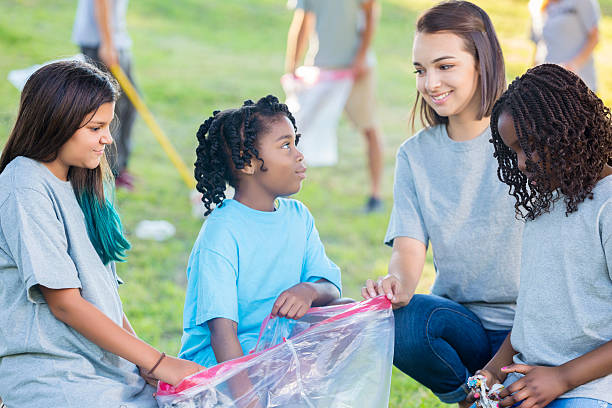istock Girls help with community clean up in the park 578284062