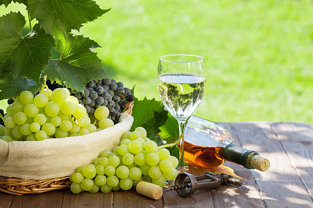 istock White wine bottle and glass, red and white grape 578284176