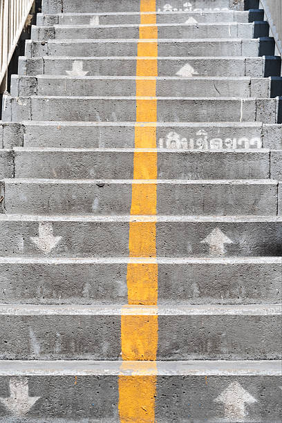 istock Concrete stairs with direction arrows and yellow vertical line 578286492