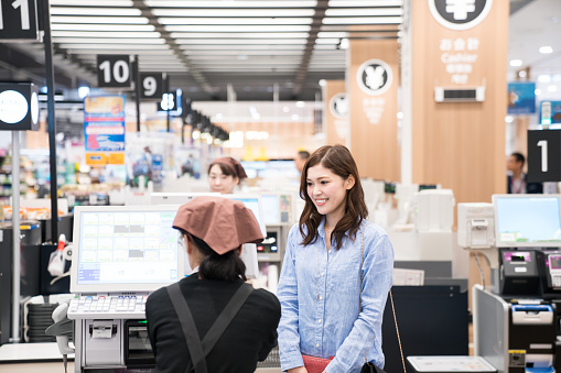 Woman at supermarket cash register ready to pay