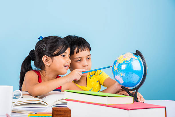 bambini indiani che studiano sul tavolo di studio - learning child education globe foto e immagini stock