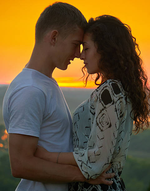 istock young couple at sunset on sky background, love concept 578294376