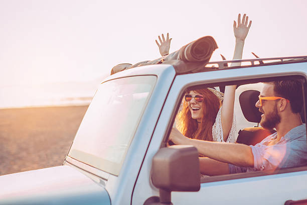 Couple on road trip Young couple driving jeep on the beach by the sea. They are happy and joyful. Enjoying in sunset and summer days. 4x4 stock pictures, royalty-free photos & images