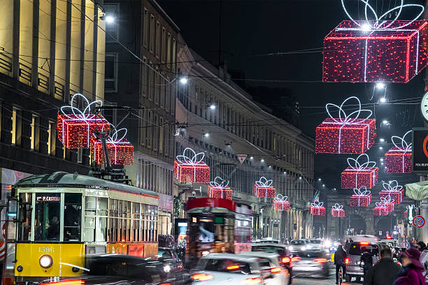Milan, Italy - December 15, 2015: Christmas lights in via Manzoni, in the old town of Milan, a city that every year welcomes visitors with decorated trees, markets and events for the Christmas holiday. People strolling in the city.