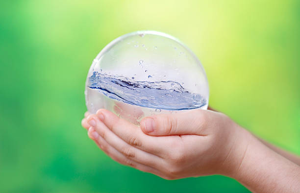 子供の手の水の地球儀 - water saving ストックフォトと画像