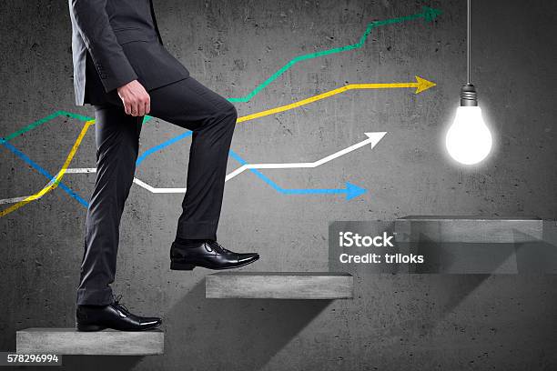 Businessman Walking Up Staircase With Colorful Line Graph Stock Photo - Download Image Now