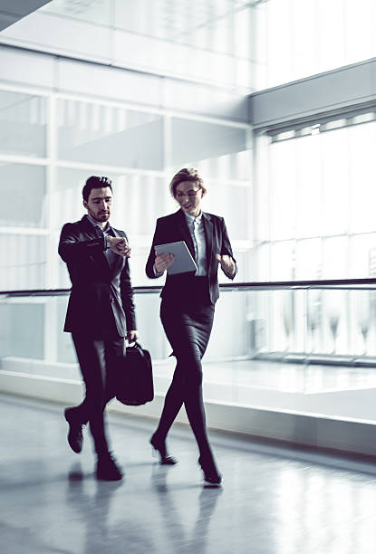 istock Two Business coworkers walking along office coridor 578299544