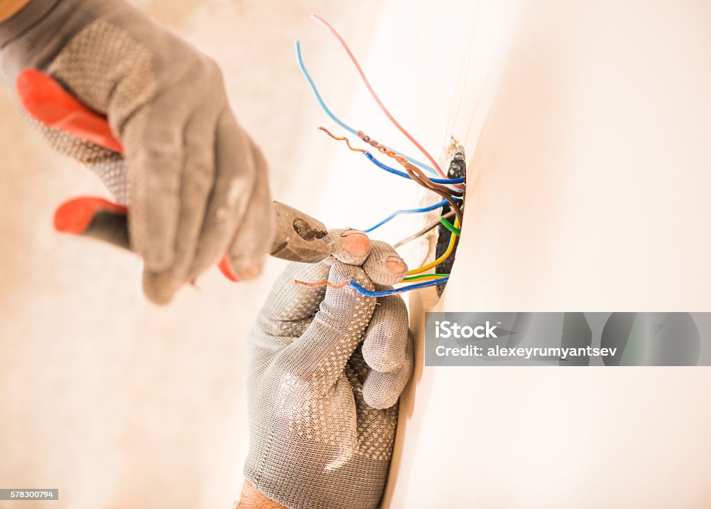 trabajador que instala los cables eléctricos - Foto de stock de Electricidad libre de derechos