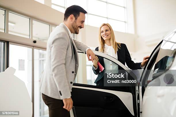 Salesperson Showing Vehicle To Potential Customer Stock Photo - Download Image Now - Car Salesperson, Car, Selling