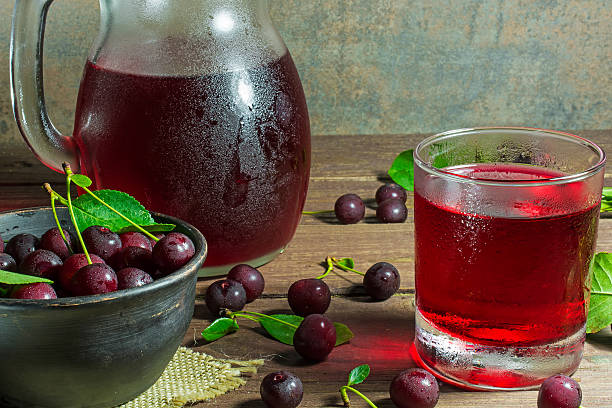 istock cold cherry juice in glass and pitcher on wooden table 578302350