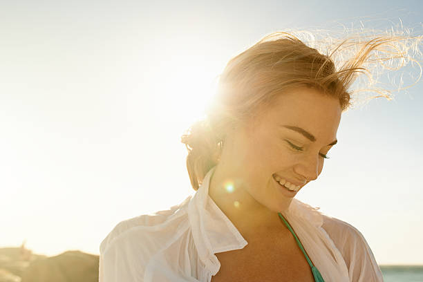 Solo in the sun Shot of a beautiful young woman at the beach serene people stock pictures, royalty-free photos & images