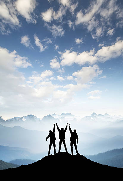 Silhouettes of team Silhouettes of team on mountain peak. Sport and active life concept climbing up a hill stock pictures, royalty-free photos & images