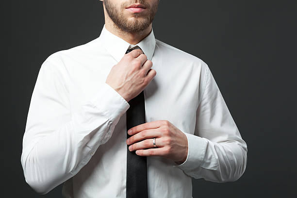 istock Mid section of young fit businessman adjusting tie isolated. 578308246