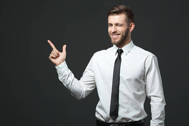 istock Young businessman holding his arm up presenting copyspace. 578308816