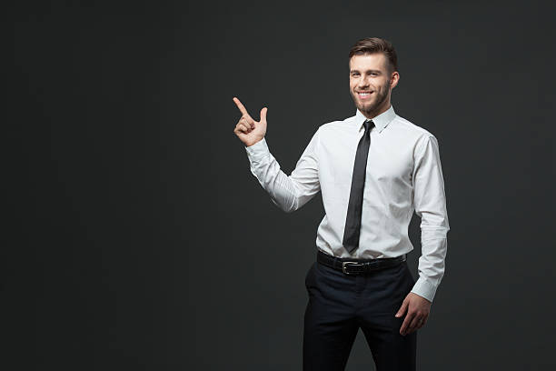 istock Young businessman holding his arm up presenting copyspace. 578308852