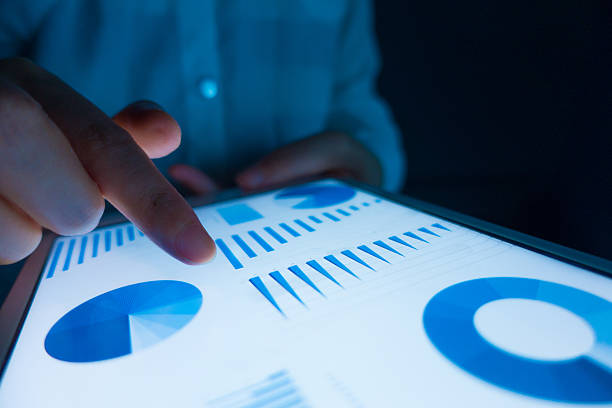 istock Business person analyzing financial statistics displayed on the tablet screen 578308904