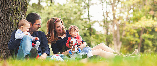 felices padres con niños al aire libre con un buen momento en familia - outdoors offspring women fall fotografías e imágenes de stock