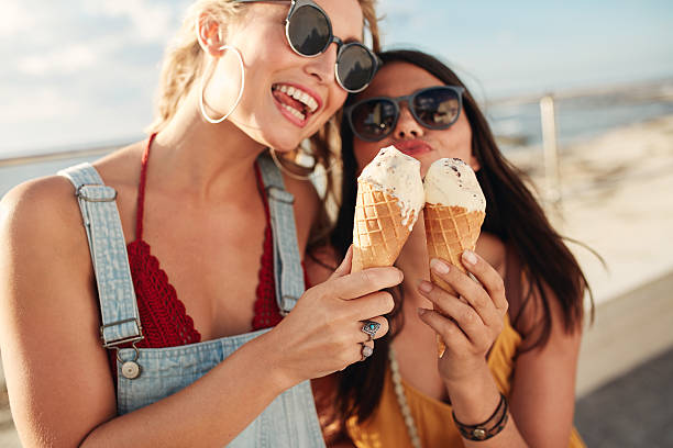 istock Two young women eating an ice cream together 578554378
