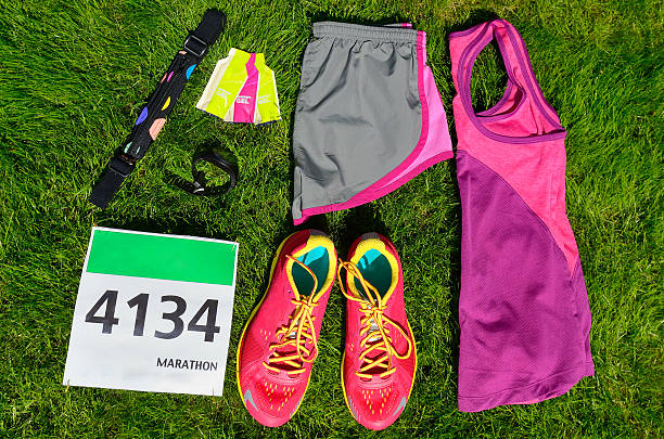 Running shoes, marathon race bib (number), runners gear Running shoes, marathon race bib (number), runners gear and energy gels on grass background, sport, fitness and healthy lifestyle concept Cross-Training for Runners stock pictures, royalty-free photos & images
