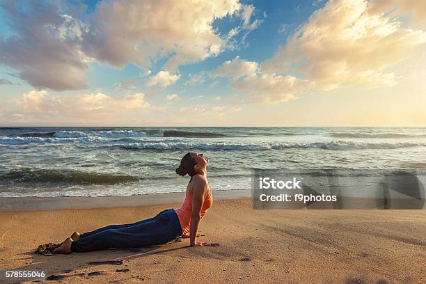 Woman Practices Yoga Asana Urdhva Mukha Svanasana At The Beach Stock Photo - Download Image Now