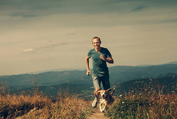 istock Man running with his dog on the mountain tableland 578555462