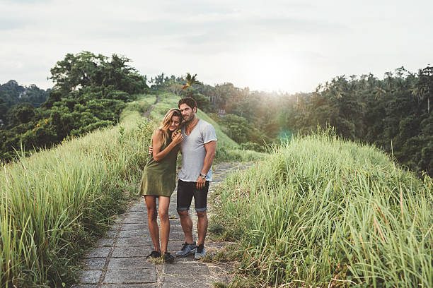 istock Young couple walking through country road 578556316