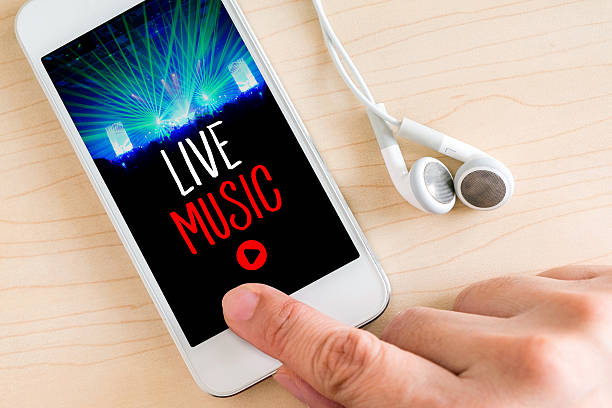 istock Hand touch smart phone and ear phone with Live music 578556326