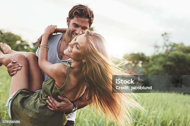 Mujer Siendo Llevada Por Su Novio En El Campo Foto de stock y más banco de imágenes de Parejas - Parejas, Verano, Hombres