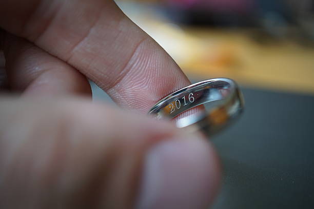 2016年の刻印付き結婚指輪を持つ男性の手 - ring wedding gold single object ストックフォトと画像
