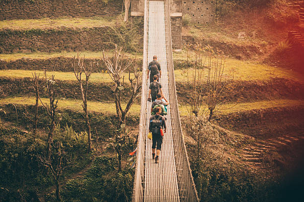 Photo of a hikers crossing the bridge in Annapurna Range on Himalayas, Nepal