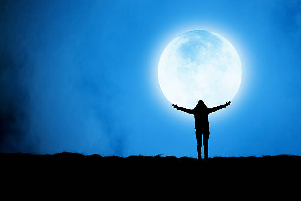 silhouette of a girl with a view of the city with a full moon