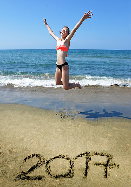 istock Jumping girl above 2017 on the beach 578562206