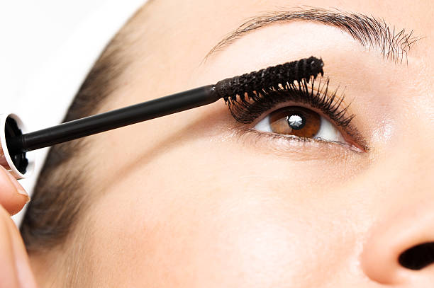 istock Woman Applying Mascara Cosmetics on White 578564422