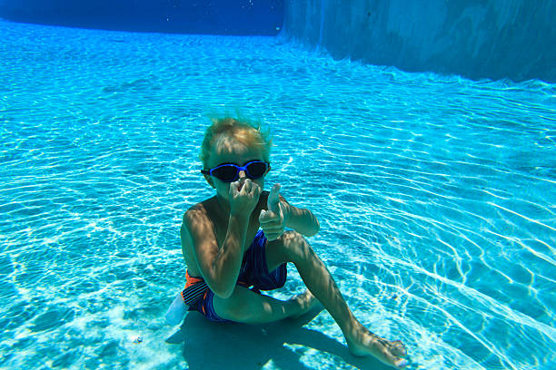 istock little boy swimming underwater, active kids 578565760