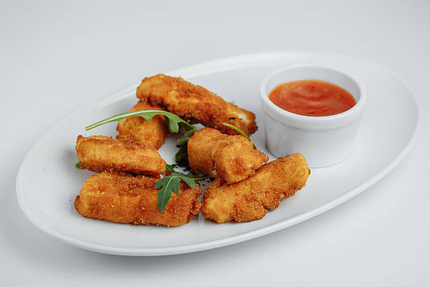 istock fried fish with sauce and arugula on a white plate 578568216