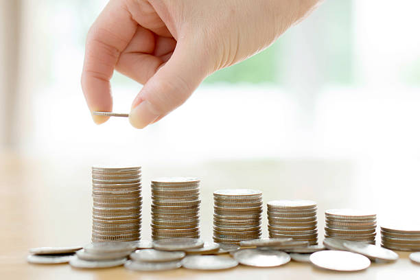 istock woman put coins to stack of coins 578573854