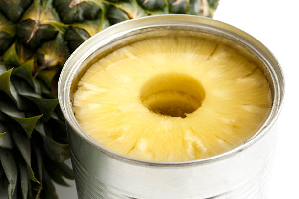 istock Pineapple rings in tin on white next to pineapple. 578575542