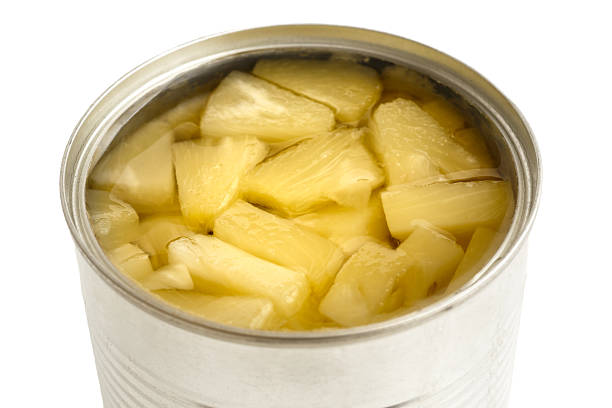 istock Pieces of pineapple in a tin in perspective on white. 578575610
