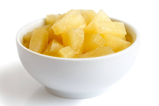 istock Canned pineapple pieces in a ceramic bowl isolated on white. 578575974