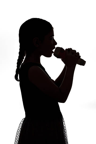 istock Singing yound girl with microphone on white background 578579310