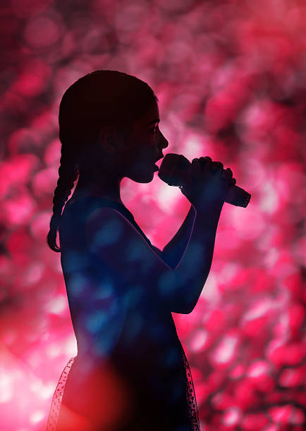 istock Singing young girl with microphone 578579416