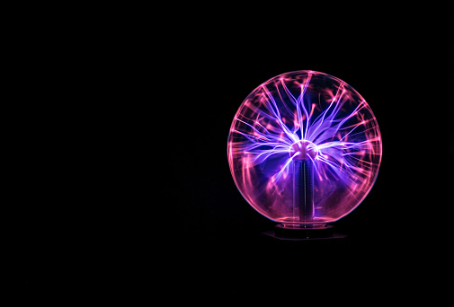 A plasma globe lit up against a black background