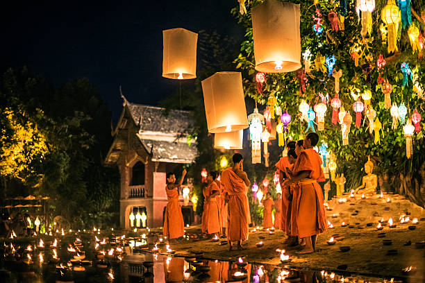 Monks at Phan Tao temple during the Loi Krathong Festival Chiang Mai, Thailand - November 24, 2015: Traditional monk lights floating balloon made of paper annually at Wat Phan Tao temple during the Loi Krathong Festival. loi krathong stock pictures, royalty-free photos & images