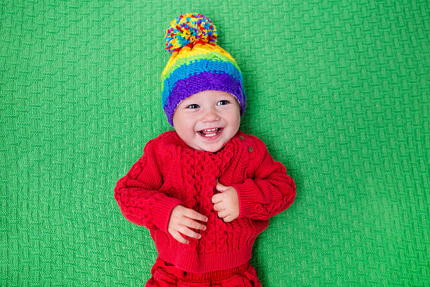 istock Little baby in warm knitted hat on green blanket 578589730