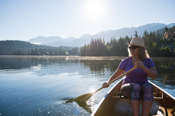 istock Senior aged woman canoeing on a pristine lake 578593552