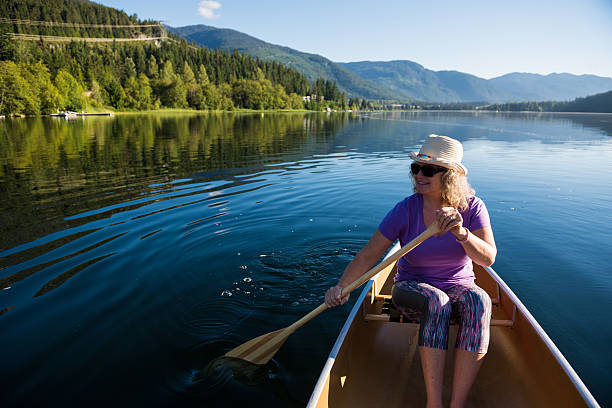 istock Senior aged woman canoeing on a pristine lake 578593814